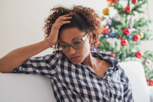 A woman sits dealing with holiday stress