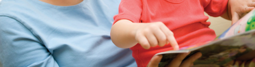 child points at book