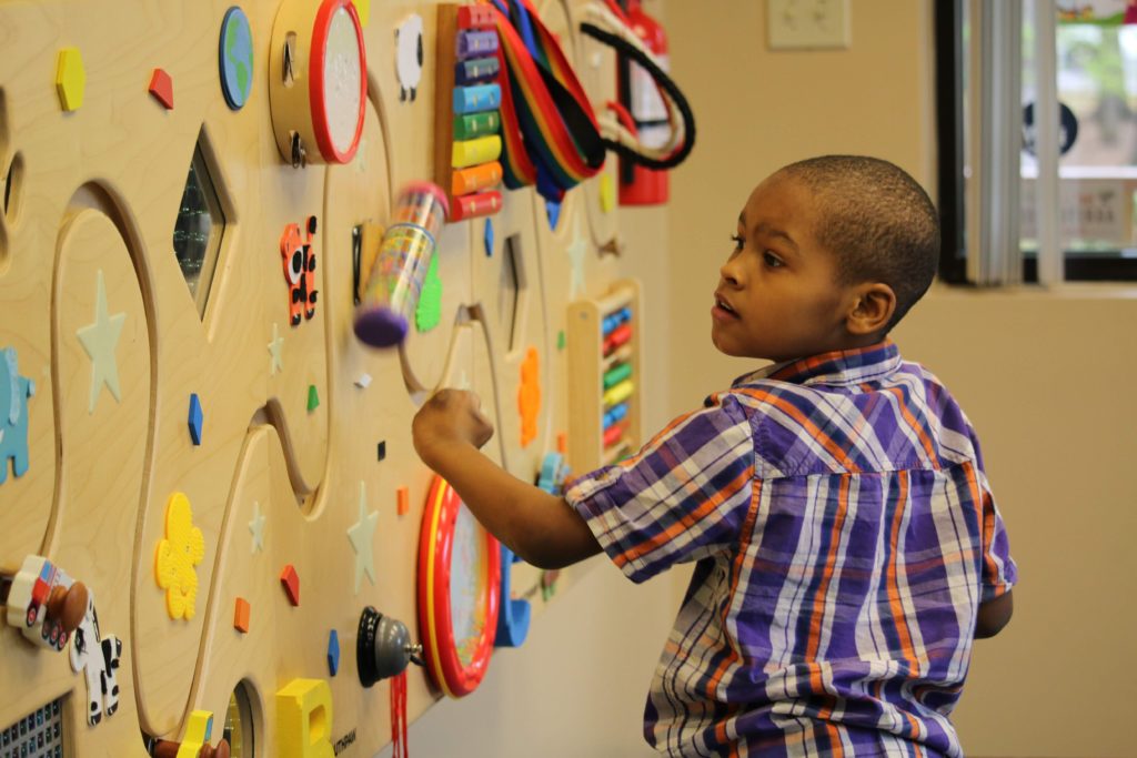 child playing with wall toy