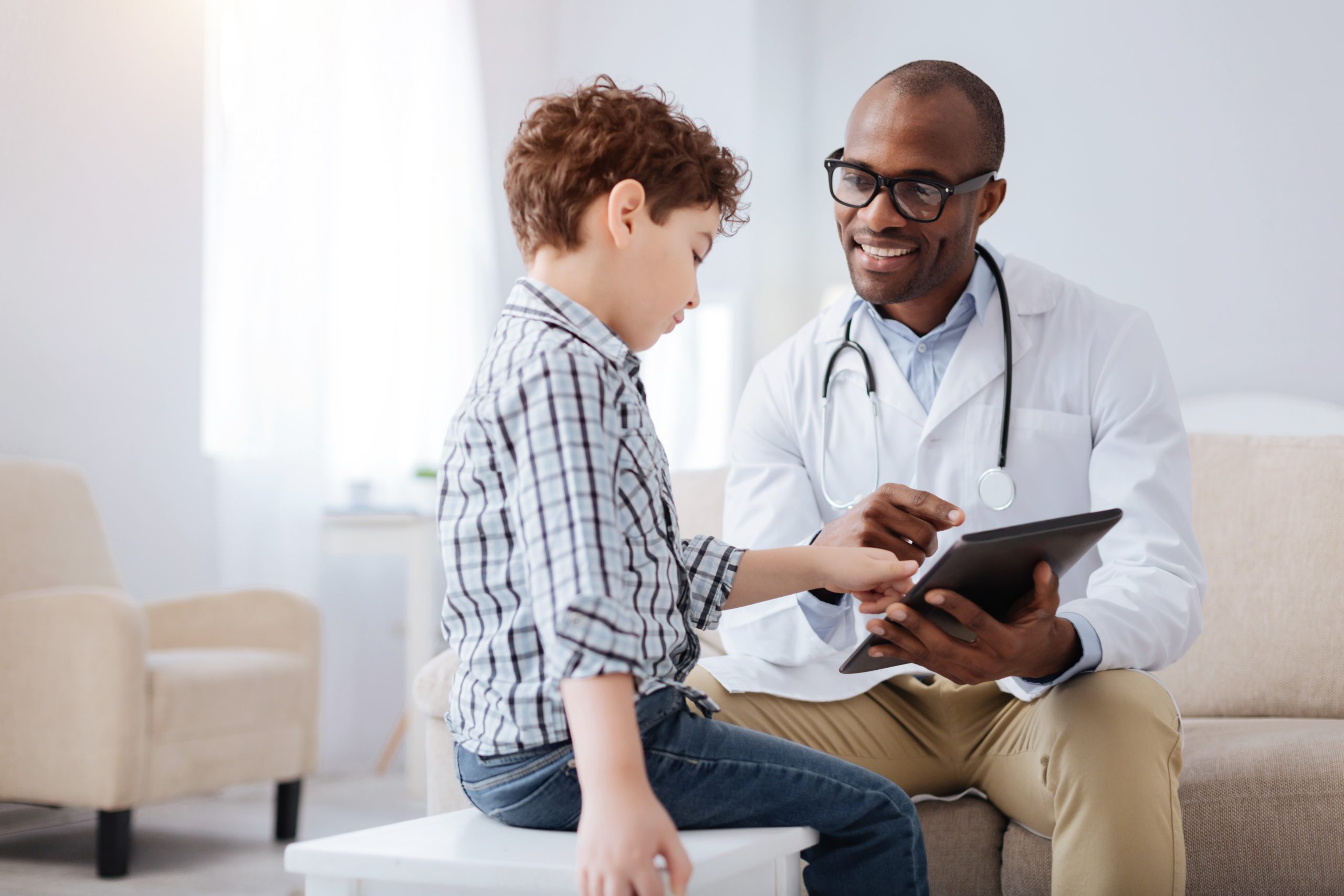 doctor sits with young patient