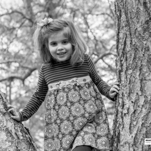 girl standing on tree limbs