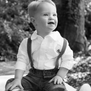 little boy sitting on blanket outside