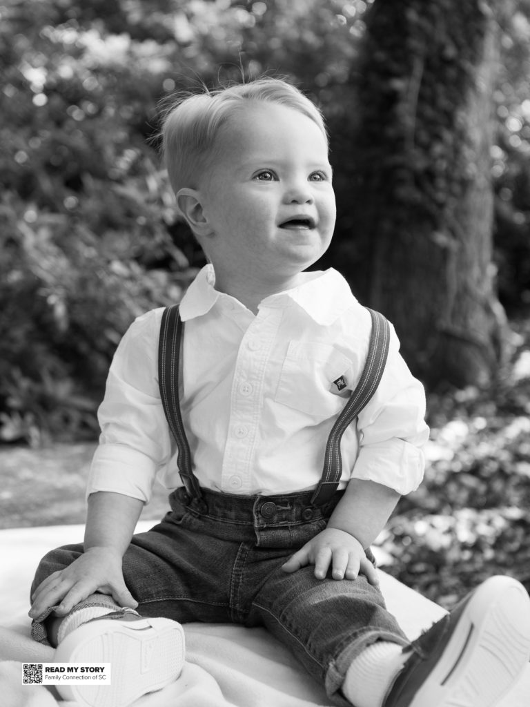 little boy sitting on blanket outside