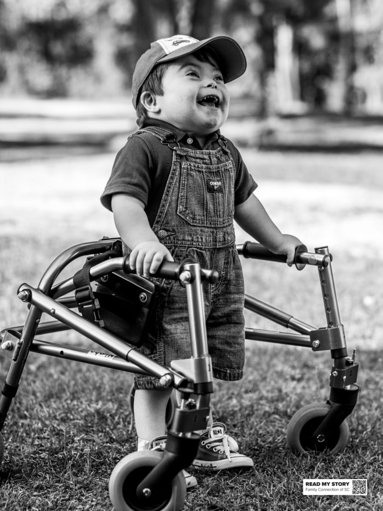 little boy standing with walker outside