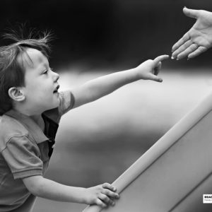 boy on slide reaching out for hand