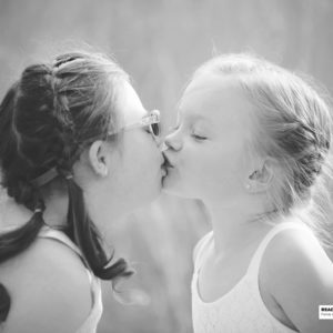 two sisters kissing