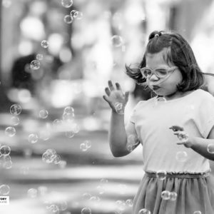 girl with glasses and bubbles floating