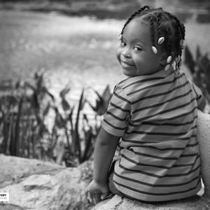 boy sitting on rock with stuffed animal