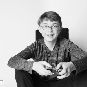boy sitting in gaming chair with remote control
