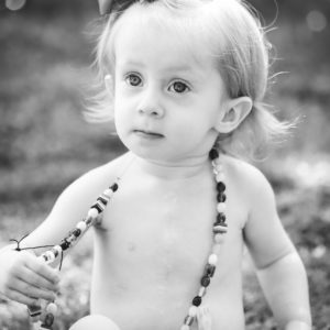 little girl outside with long bead necklace