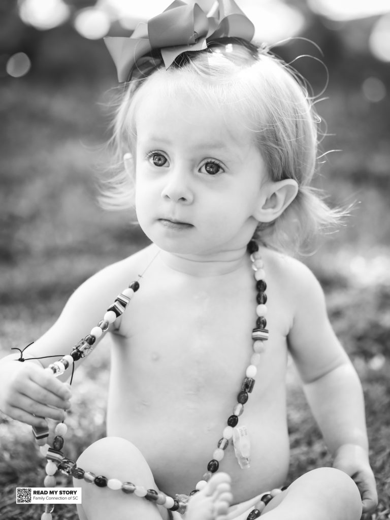 little girl outside with long bead necklace