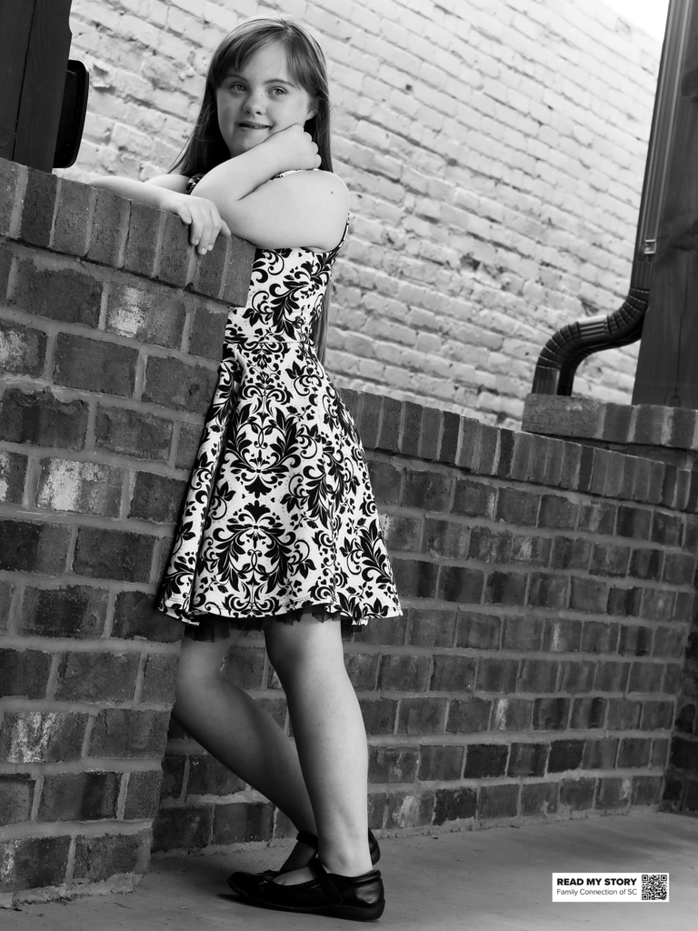 girl leans on a brick wall