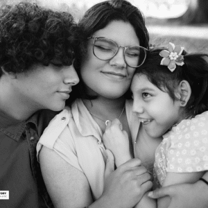 girl in a group hug with her brother and sister