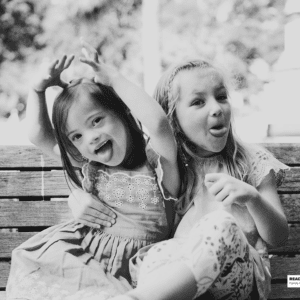 two sisters sit on bench