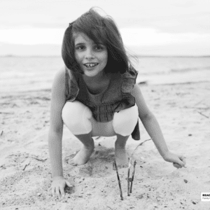 girl plays in the sand on the beach