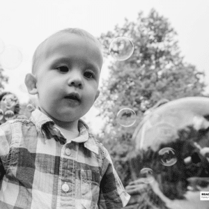 young boy plays with bubbles