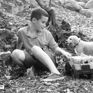 Boy and a Puppy play with trucks
