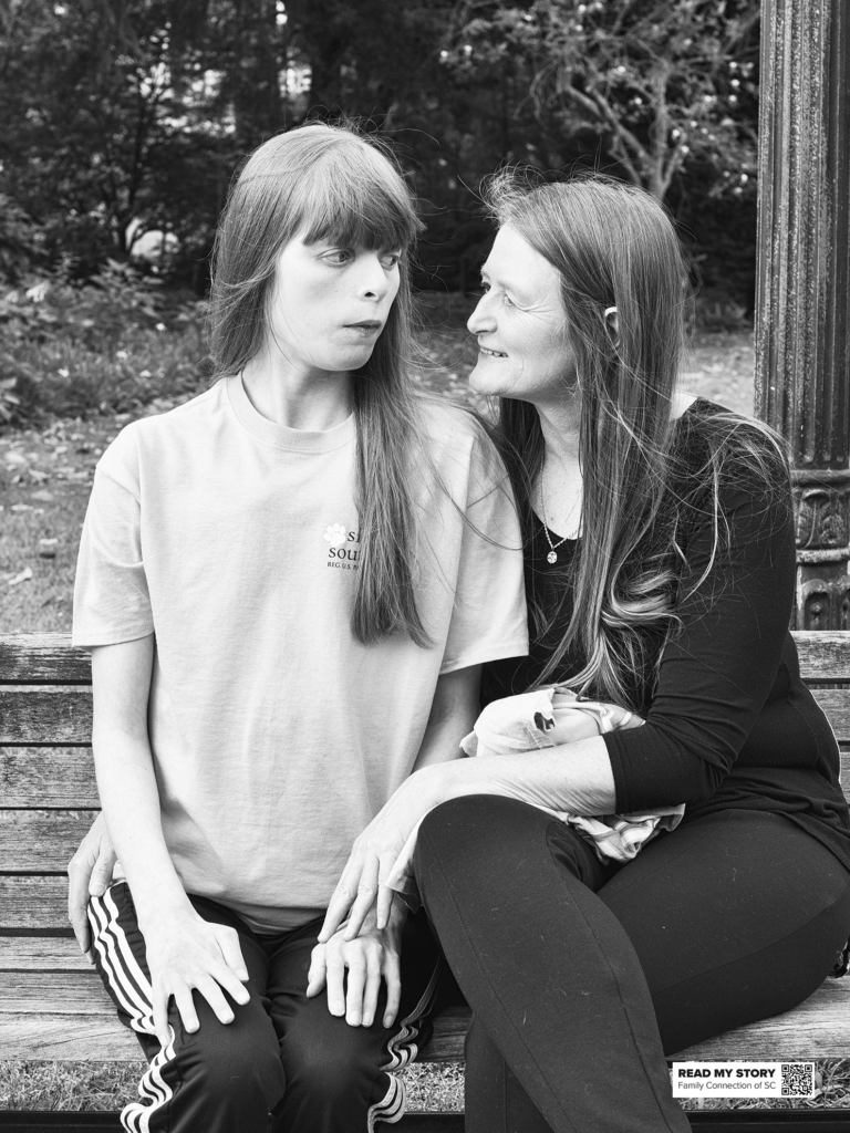 mother and daughter sit on a park bench