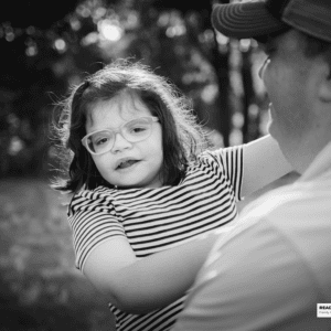 young girl is held by her father