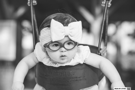 young girl sits in a swing