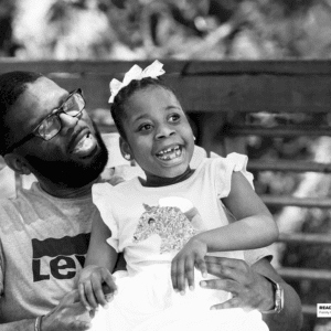 girl sits with her father