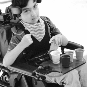 boy sits in his chair and using cups