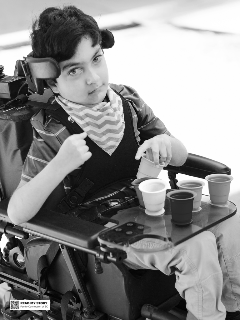 boy sits in his chair and using cups