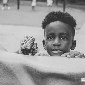 boy plays with toy cars in the park