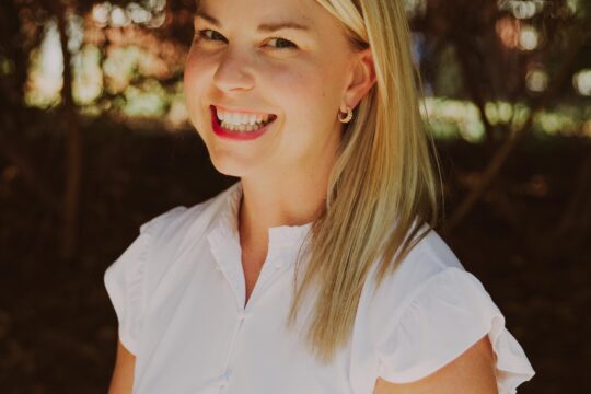 blond woman in white dress smiling outside