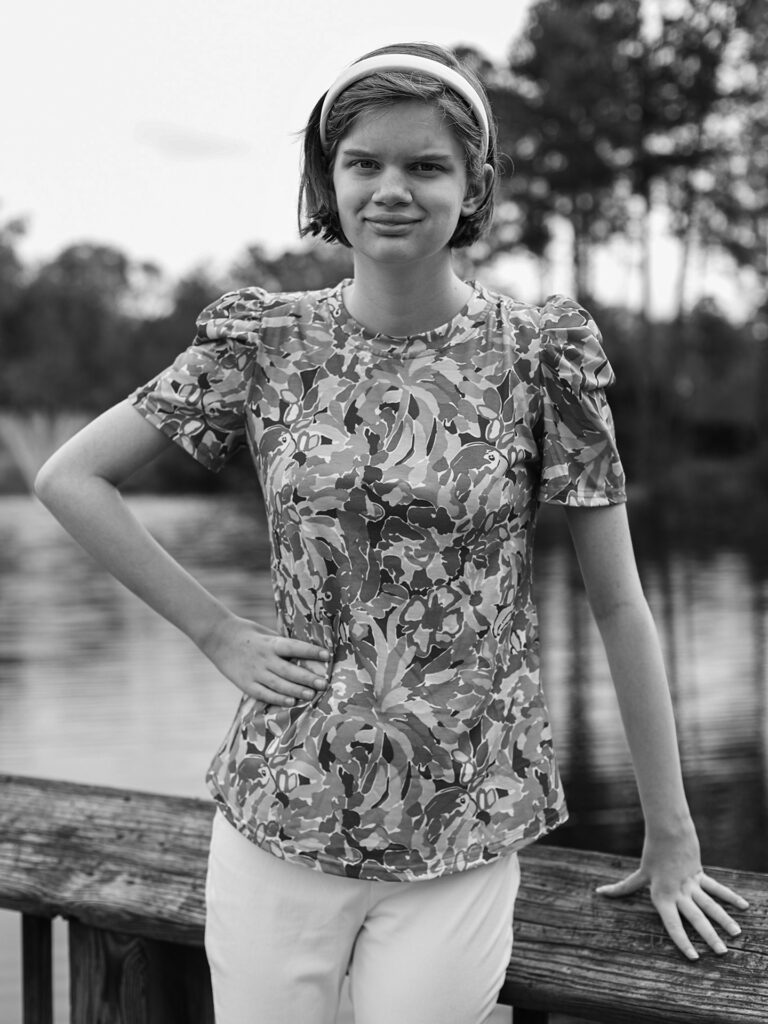 young woman smiles by the water
