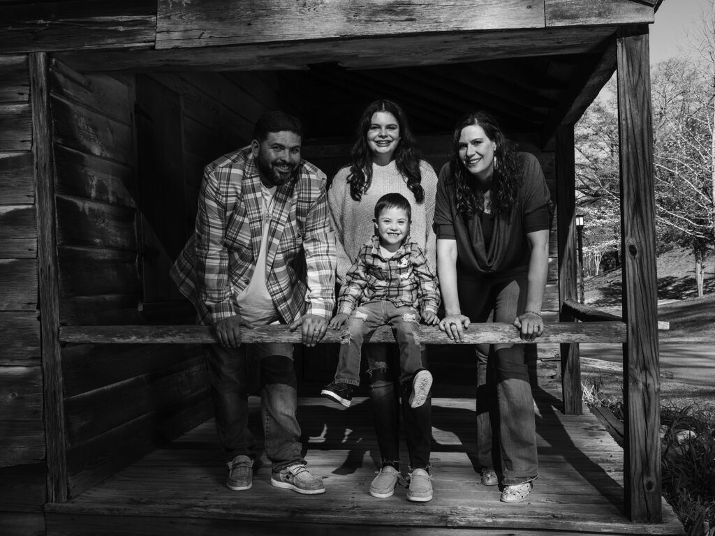 family smiles from porch