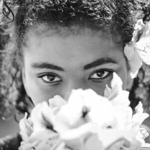 young woman looks over a flower
