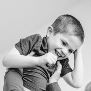 boy smiles being held overhead
