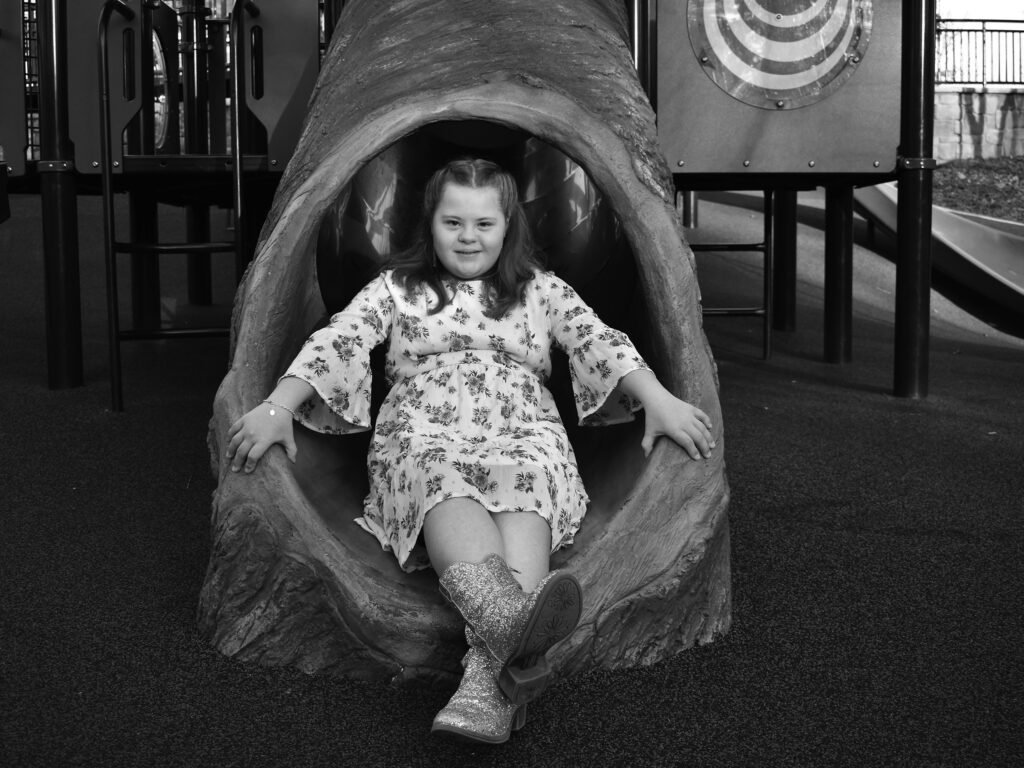 young woman in boots sits on a slide