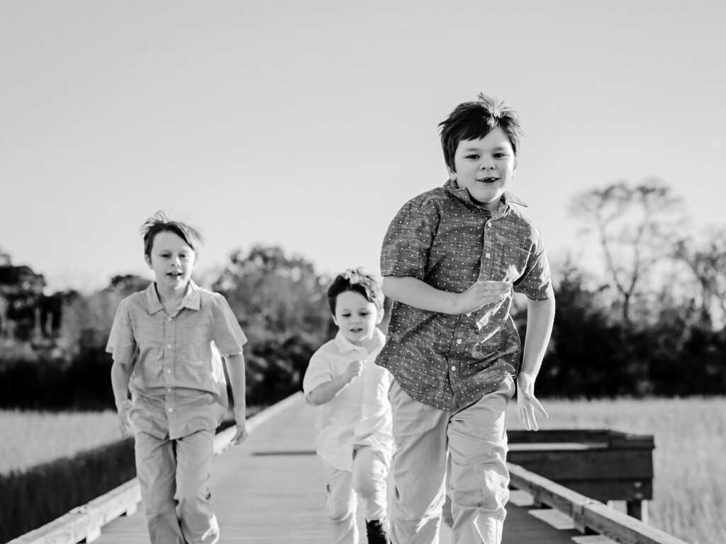 three children run down a board walk