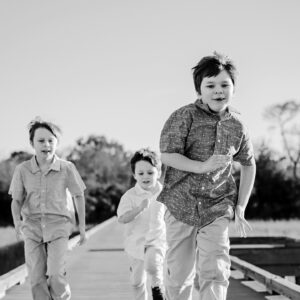 three children run down a board walk