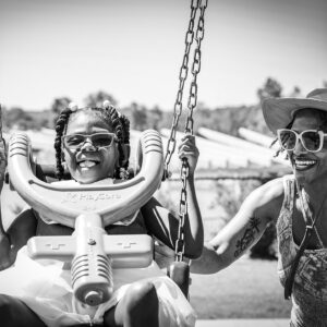 mother pushes daughter in a swing