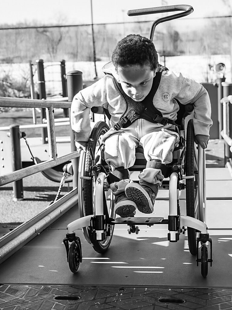 young boy pushes himself in a wheelchair