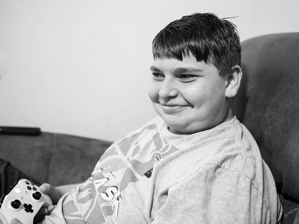 young man smiles playing video games