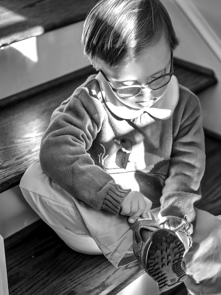 young boy puts on his shoes