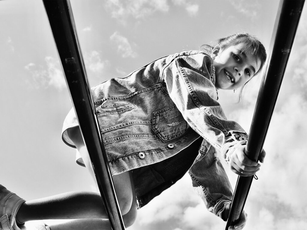 girl climbing monky bars