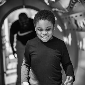 niño caminando por un tunel con papa siguiendolo