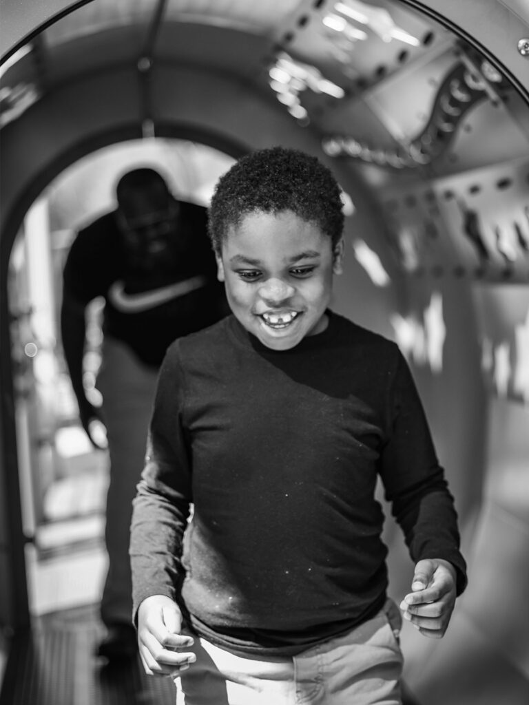 niño caminando por un tunel con papa siguiendolo