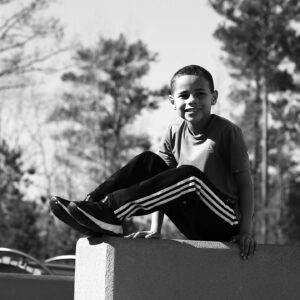 niño sentado en una pared