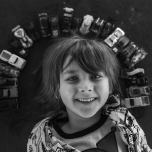 niño con coches de juguete dispuestos alrededor de su cabeza.