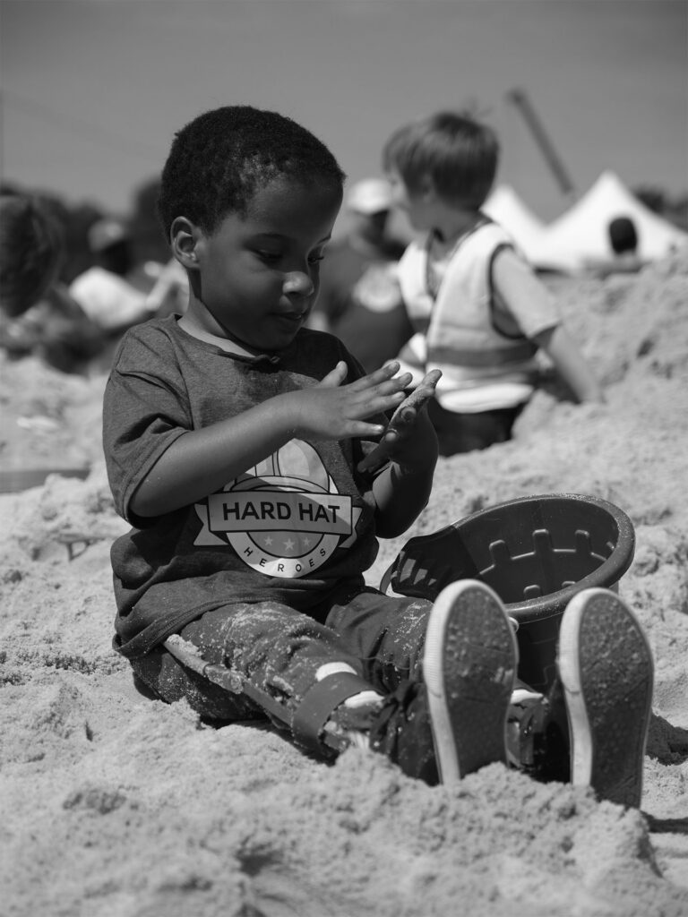 young boy plays in the sand
