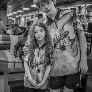 hermano y hermana jugando juntos a los bolos en un equipo