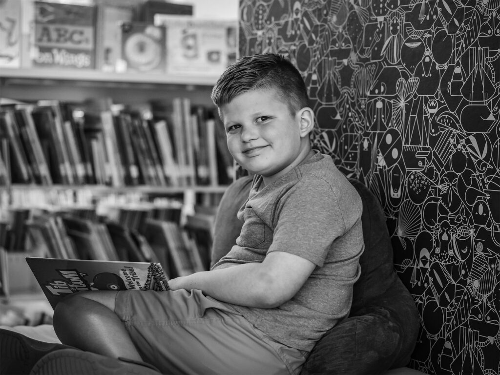 niño sentado leyendo en un rincón