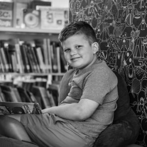 niño sentado leyendo en un rincón