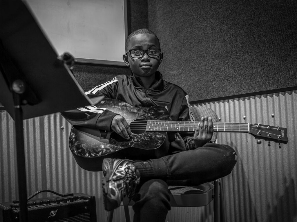 young boy plays the guitar